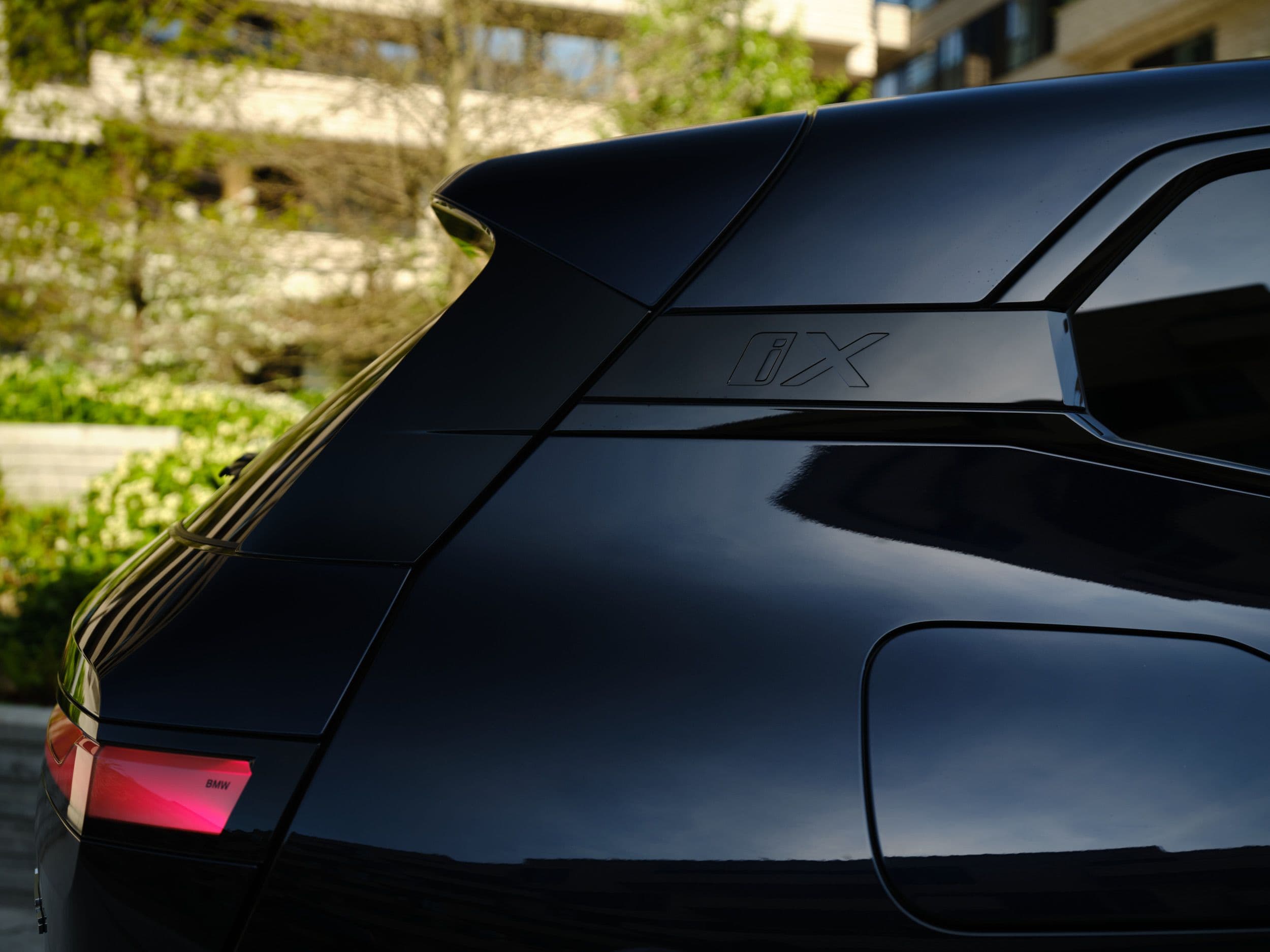Close-up of the sleek, black rear spoiler and taillight of a modern SUV.