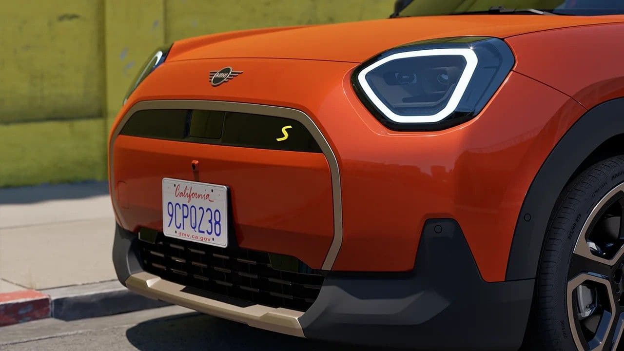 Orange Mini Cooper S with California license plate parked on a street.