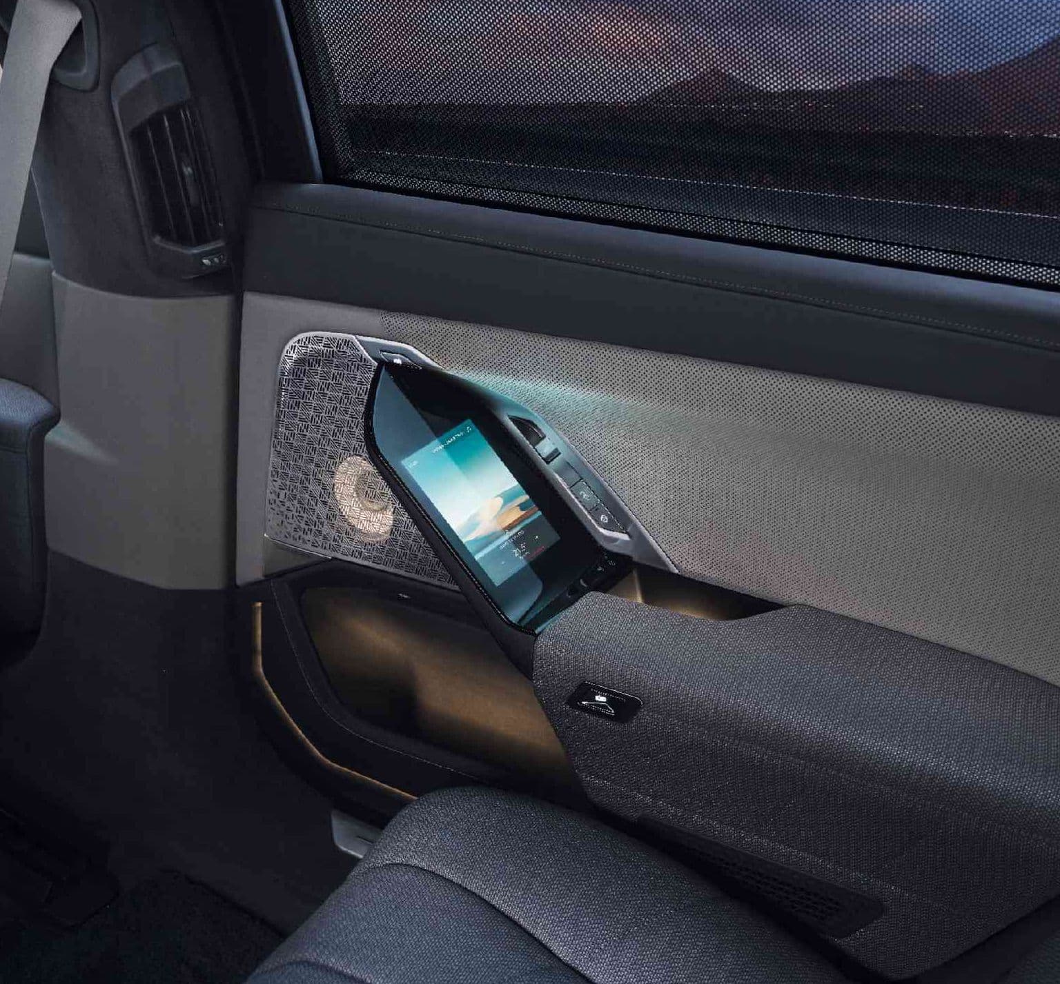 Close-up of a car's interior door panel showing a digital screen embedded in the armrest.