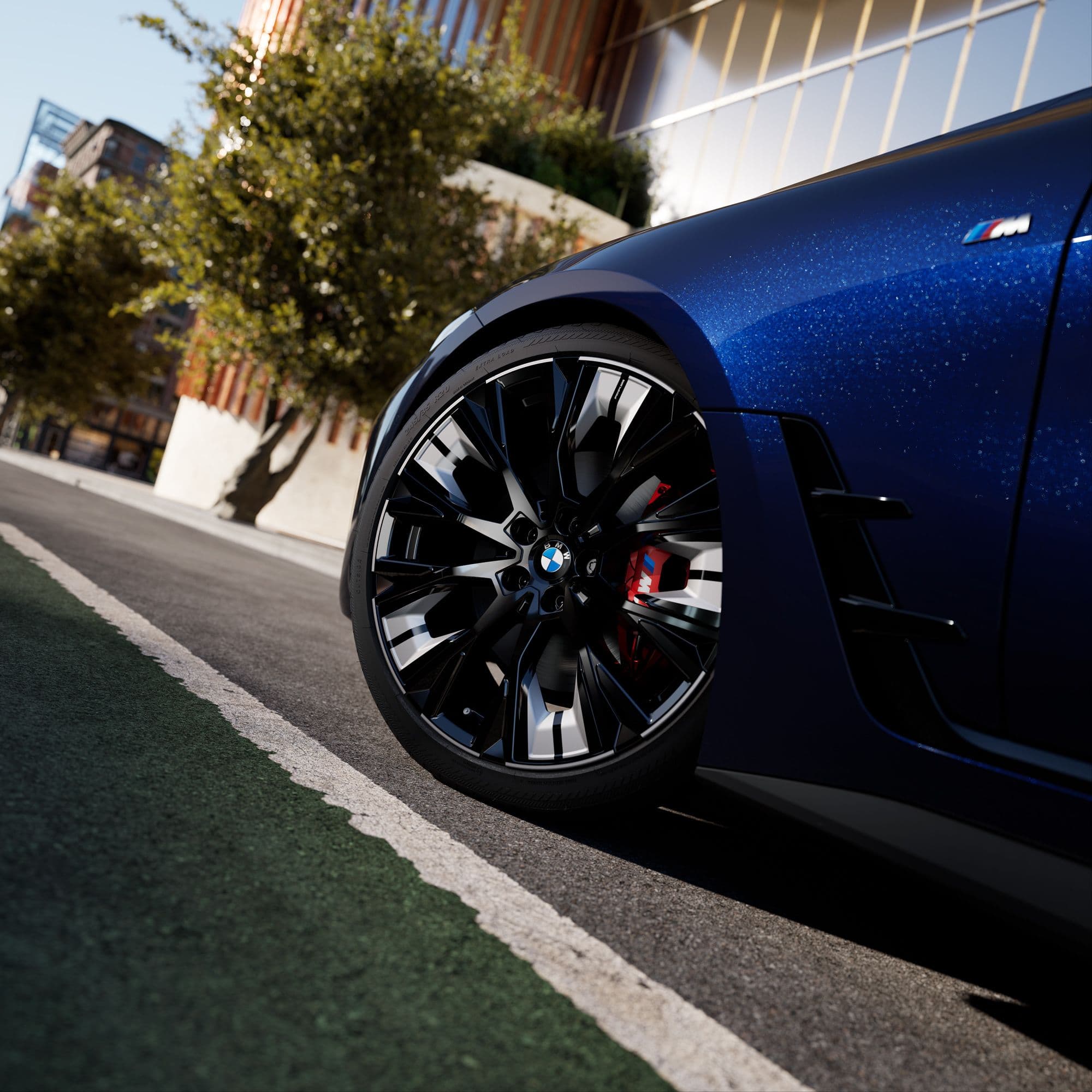 Close-up of a shiny blue car's intricate black and silver wheel with red brake calipers.