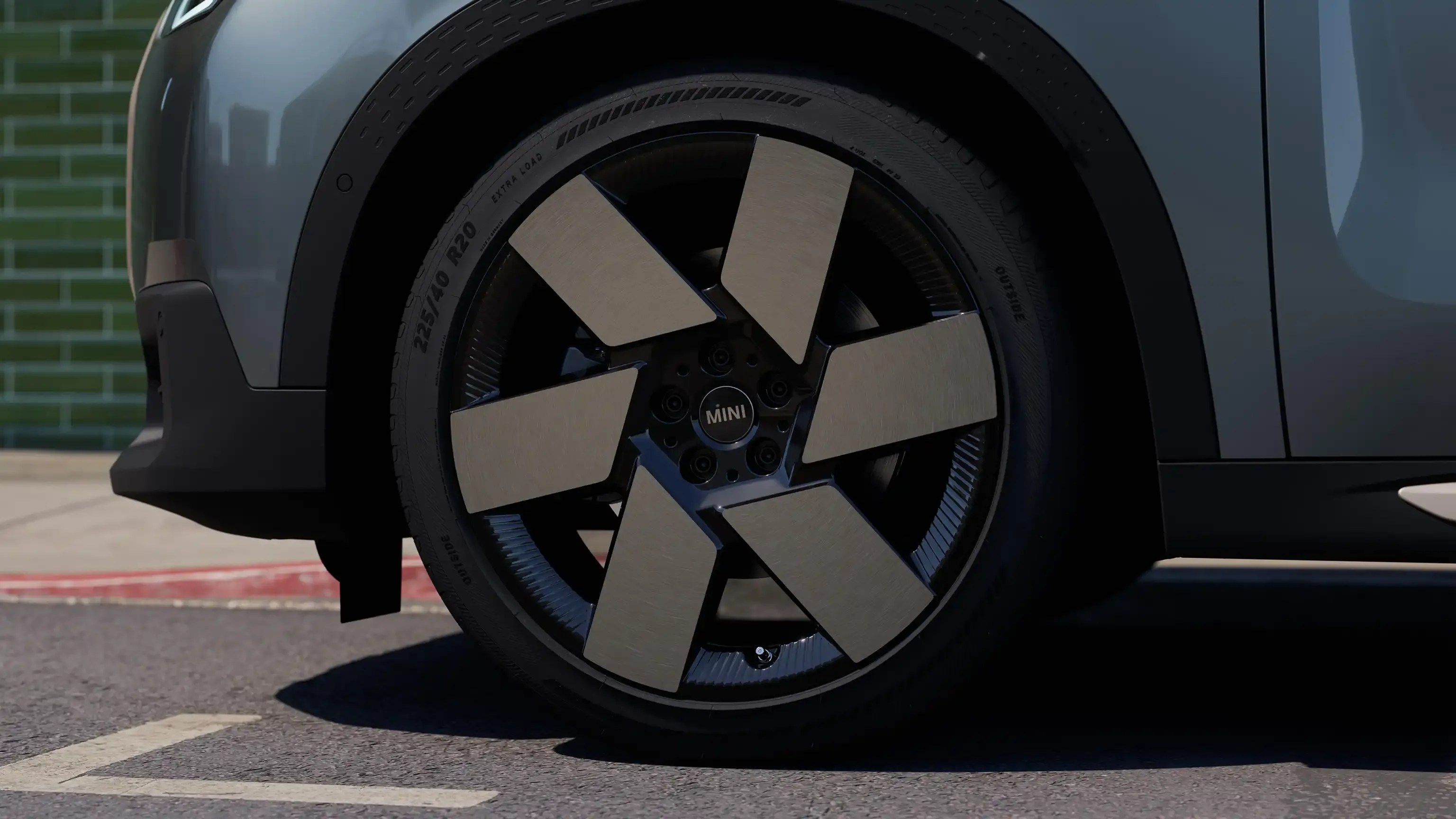 Close-up of a dark grey car's futuristic wheel with six angular spokes.