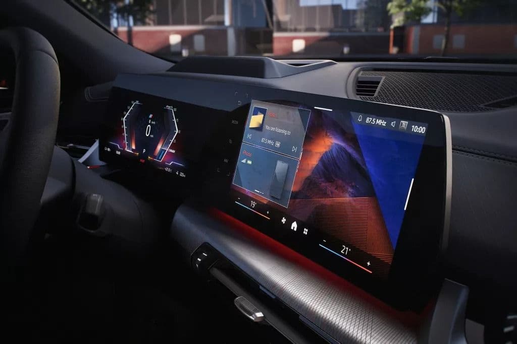 Modern car dashboard with large curved infotainment screen and digital driver display.