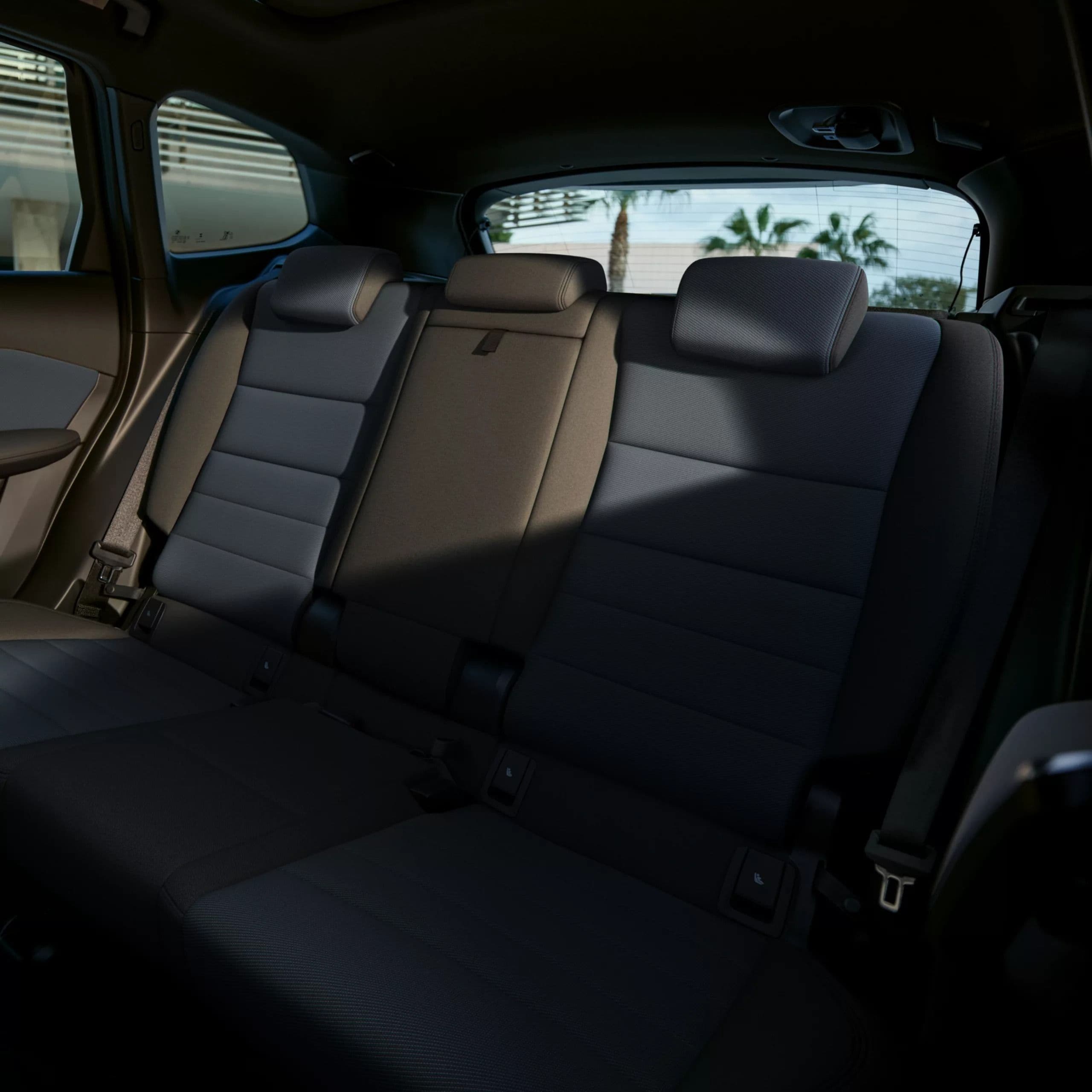 Interior view of a car's rear seats with gray upholstery and headrests.