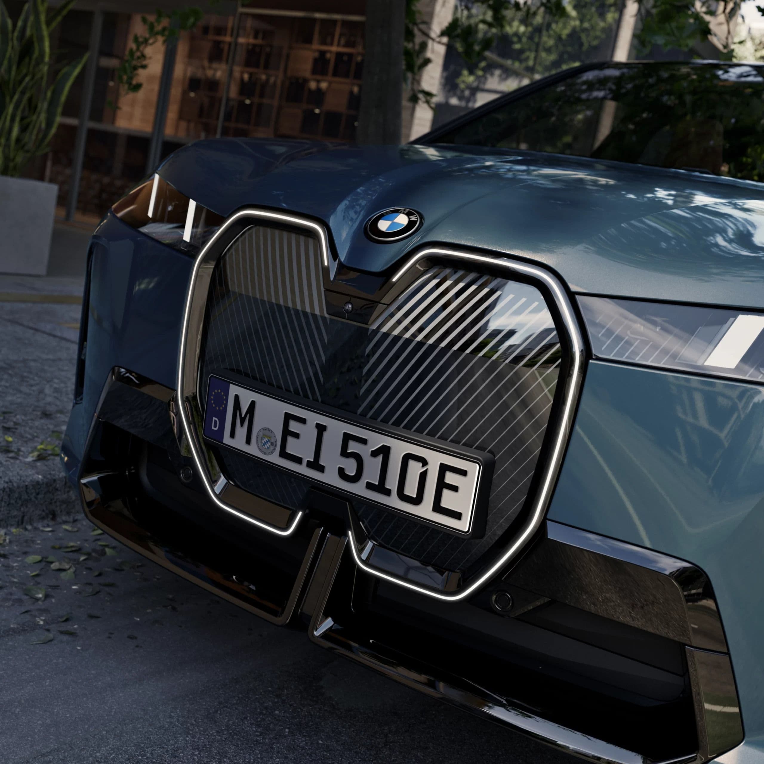 Close-up of a dark teal BMW iX electric SUV's front grille and license plate.